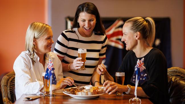 Sara Rehn, Mariele Fretta and Felicity Rowe celebrate at the Kent Town Hotel in Adelaide with the Australia Day mixed grill … and plenty of patriotism. Picture Matt Turner