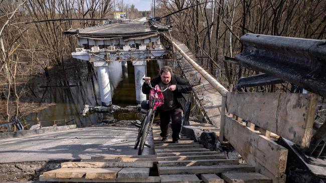 A man crosses a destroyed bridge near the village of Bohorodychne in the Donbass region of Ukraine. Picture: AFP