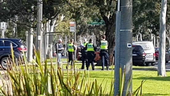 Officers gather by the road in Mulgrave.