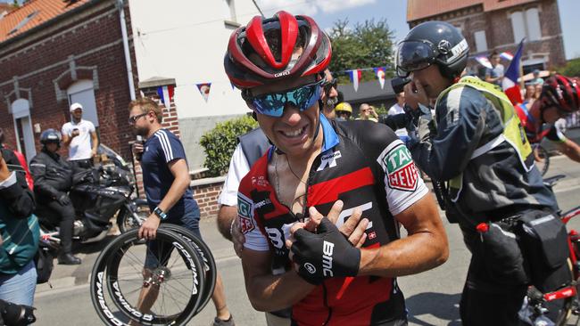 Richie Porte holds his right arm after crashing during the ninth stage of the Tour. Picture: AP