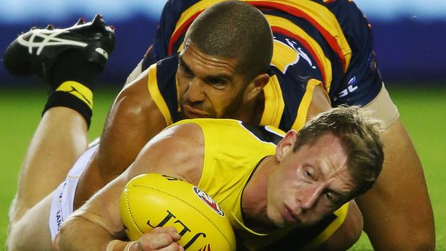 Curtly Hampton of the Crows tackles Dylan Grimes of the Tigers.