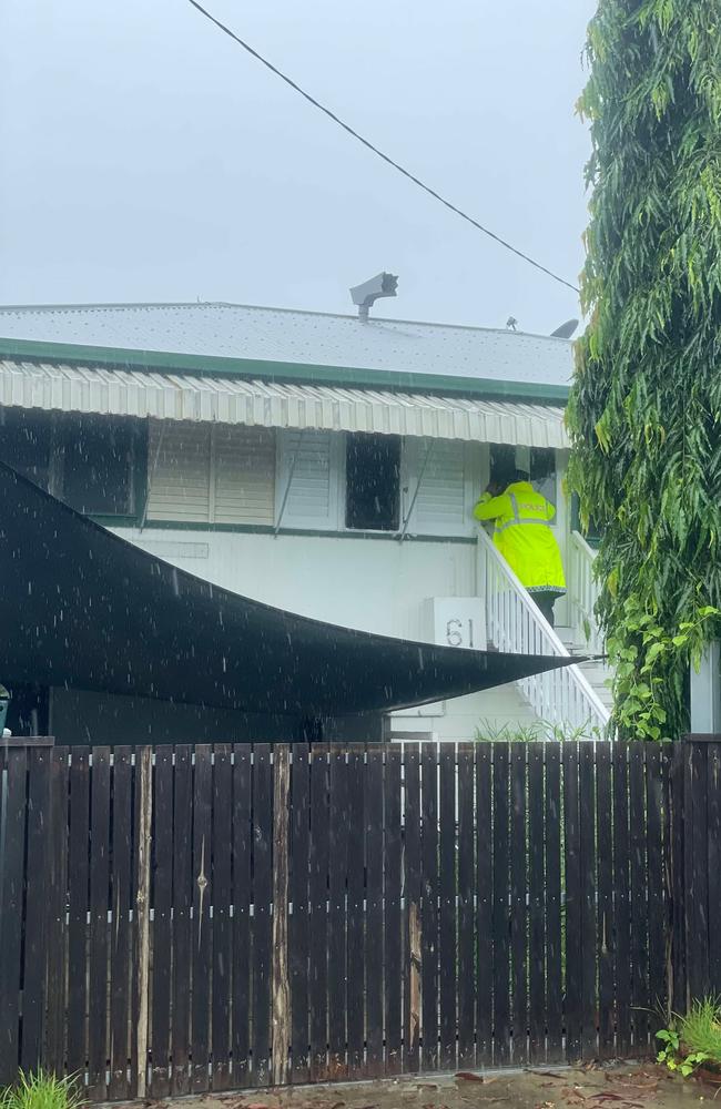 Police at the door of a property on 12th Ave, Railway Estate.