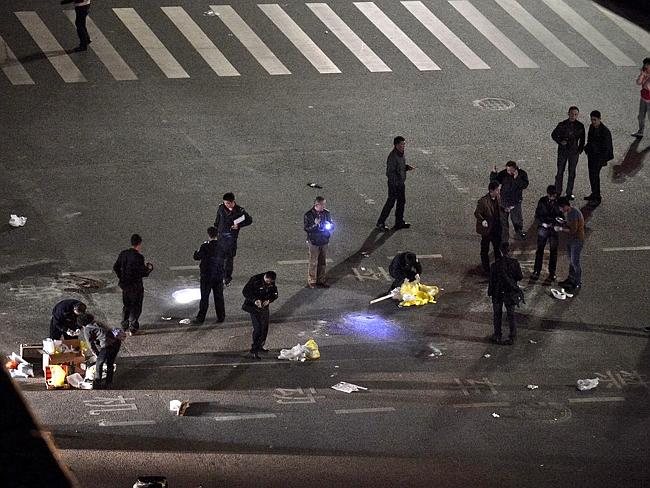 Mass stabbing ... police officers investigate the crime scene after an attack by knife wielding men left 28 people dead in Kunming, in south-western China's Yunnan province. Picture: AP