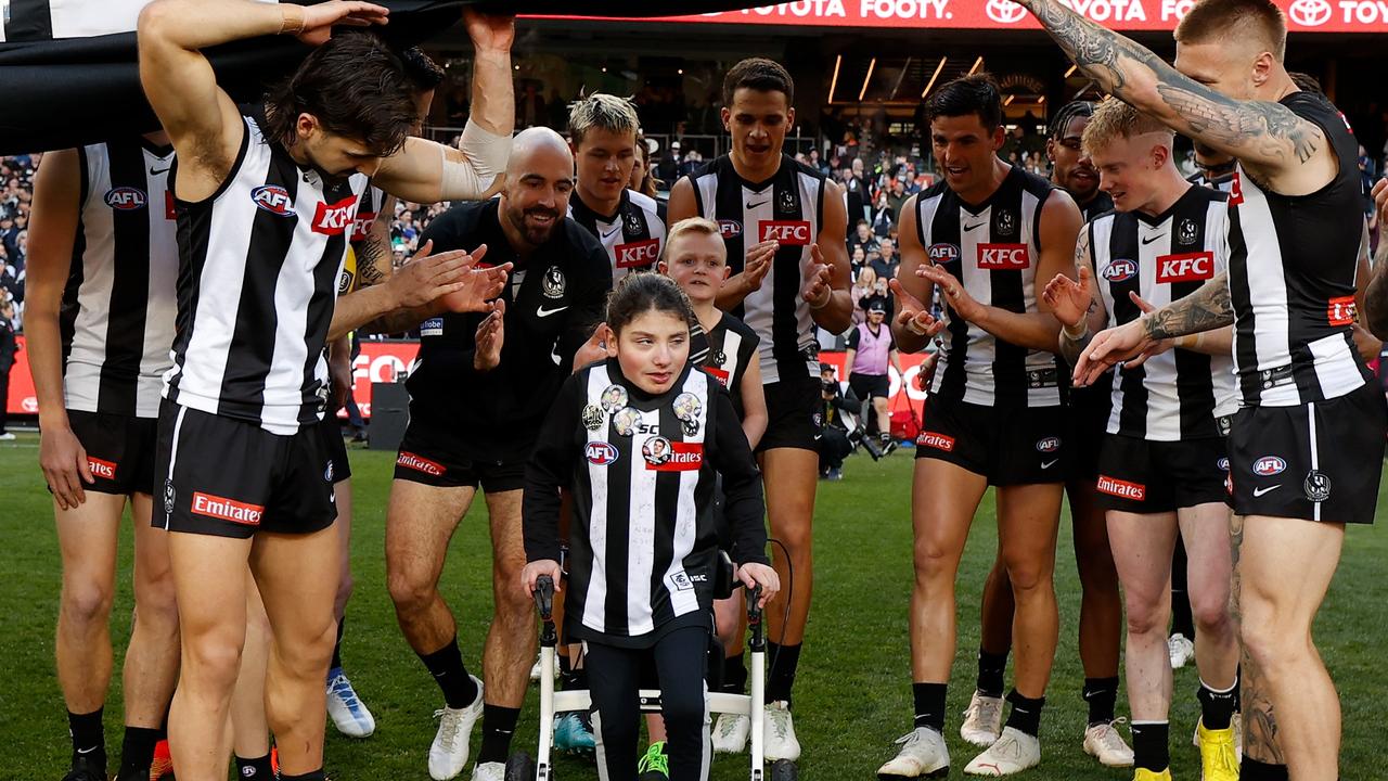 The Magpies assist little Alieha through their banner before their qualifying final with Geelong. Picture: Michael Willson
