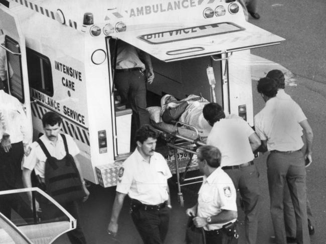 Detective Steve Canellis is loaded into an ambulance after being shot by Hakki Atahan. File picture