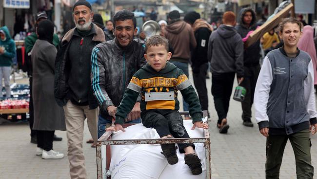 A displaced Palestinian youth pushes a cart loaded with bags of flour they received from the UNRWA in Rafah on Sunday. Picture: AFP