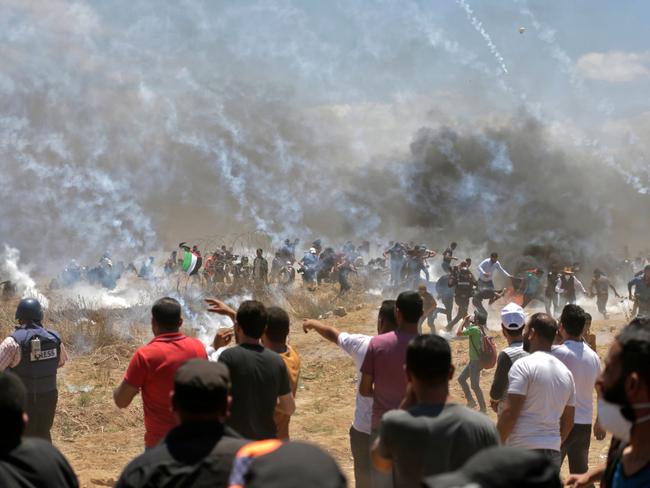 Palestinian protesters run for cover from tear gas during clashes with Israeli forces. Picture: AFP