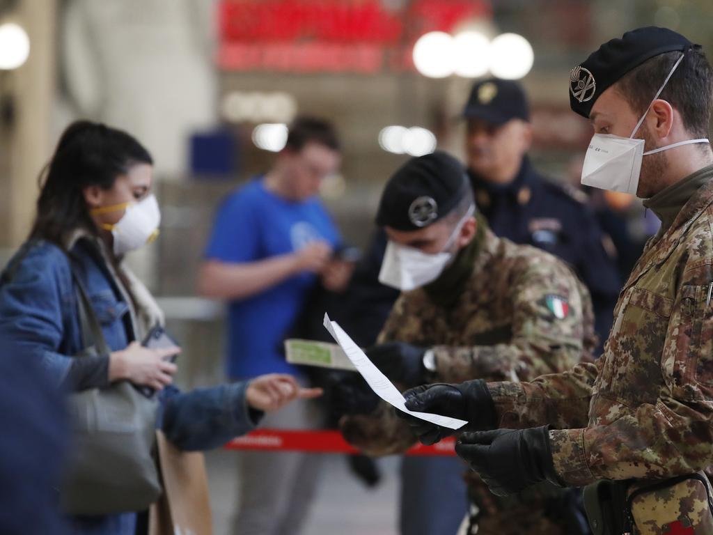 Police officers and military personnel in Milan have been grilling people on how essential their travel is. Picture: Antonio Calanni/AP