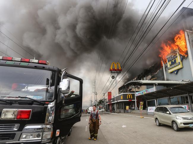 A firefighter standing in front of a burning shopping mall in Davao City on the southern Philippine island of Mindanao. Picture: AFP