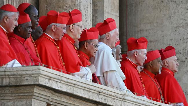 Cardinals react from a balcony of the St Peter's Basilica, as the new pope makes his first appearance. (Photo by Andrej ISAKOVIC / AFP)