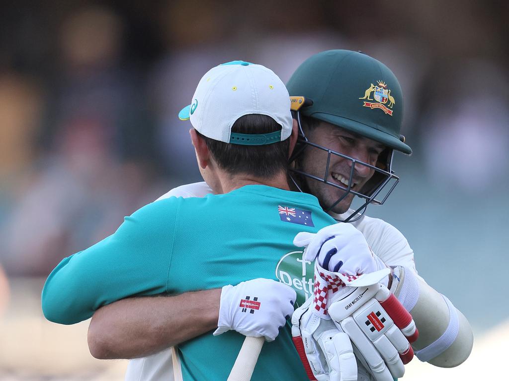 Joe Burns and Justin Langer share a hug.