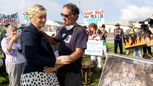 Zali Steggall hugs bushfire survivor Nick Hopkins of Malua Bay, pictured with debris from his house at Parliament House on February 11, 2020 in Canberra, Australia. The protesters are making a symbolic "trail of destruction" that leads from parliament to the Minerals Council of Australia's head office to urge businesses and politicians to cut ties with mining lobbyists. (Photo by Tracey Nearmy/Getty Images)