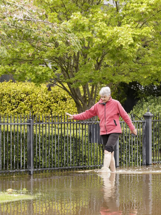 Julie Lunson walks through flood waters from her home in Latrobe. Picture: Grant Viney