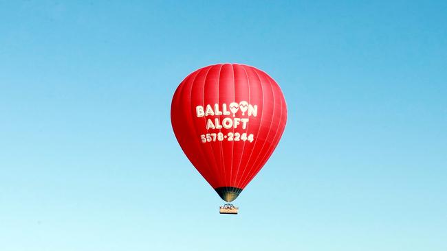 A hot air balloon comes down to land in the early morning at Emerald Lakes, Gold Coast.