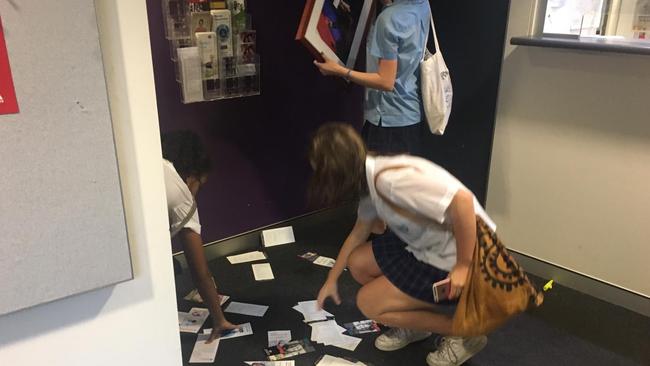 Pamphlets litter the office floor after the protest while the picture is put back on the wall. Picture: Adella Beaini