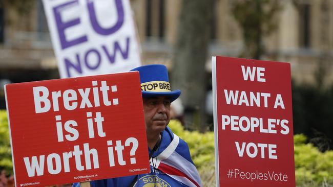 Pro and anti Brexit protesters hold placards near Parliament in London.