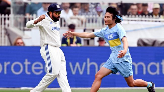 India captain Rohit Sharma managed to avoid the invader. (Photo by William WEST / AFP)