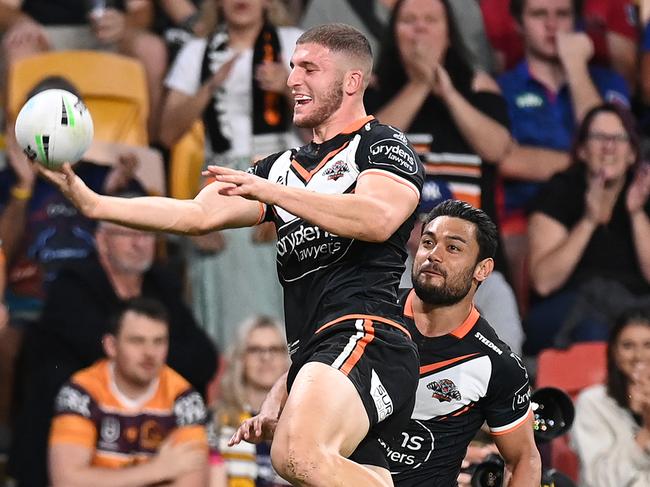 BRISBANE, AUSTRALIA - MAY 14:  Adam Doueihi of the Tigers celebrates with team mates after scoring a try during the round 10 NRL match between the Wests Tigers and the Newcastle Knights at Suncorp Stadium on May 14, 2021, in Brisbane, Australia. (Photo by Bradley Kanaris/Getty Images)