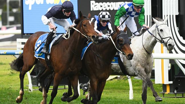 Rezone (left) overhauls stablemate Eye For An Eye (checked cap) with Boga Legend (right) just behind at Caulfield on Saturday. Picture: Vince Caligiuri / Getty Images