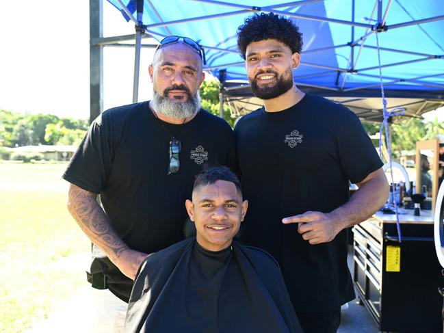 Rob Hodge with Fresh Start Academy barber trainee Feao Tongia, 21, and Sidsulai Ingui, 15, in the chair at Shang Street Park. Picture: Isaac McCarthy