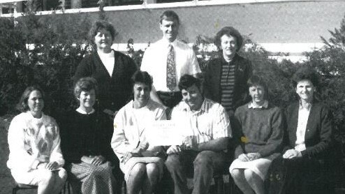 Widgee State School staff members in 1992: Back: Stella Simpson (teacher), John Webster (Principal), Bev Betts (teacher). Front: Fay Hawkins (admin assistant), Coral Stancombe (teacher aide), Sherry Fuller (cleaner), Terry Payne (groundsman), Carolyn McCarthy (admin assistant) and Julia Webb (teacher aide).