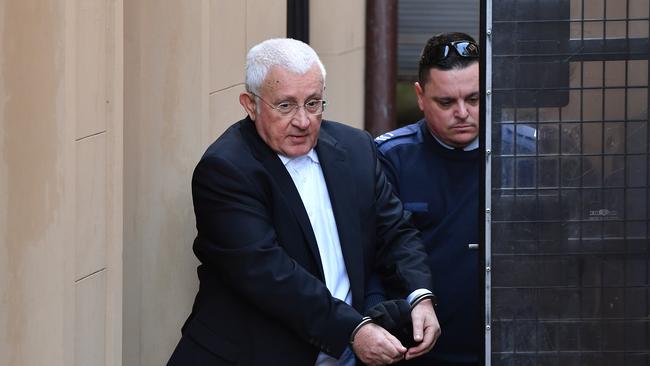 Ron Medich is led from court 