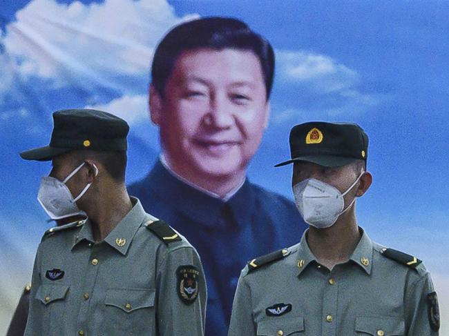 BEIJING, CHINA - MAY 20: Soldiers of the People's Liberation Army's Honour Guard Battalion wear protective masks as they stand at attention in front of photo of China's president Xi Jinping at their barracks outside the Forbidden City, near Tiananmen Square, on May 20, 2020 in Beijing, China. China's government will open its annual weeklong meetings known as the 'two sessions' at the Great Hall of the People on May 21st. They were delayed in March due to the COVID-19 pandemic. After decades of growth, officials recently said China's economy had shrunk in the latest quarter due to the impact of the coronavirus epidemic. The slump in the worlds second largest economy is regarded as a sign of difficult times ahead for the global economy. While industrial sectors in China are showing signs of reviving production, a majority of private companies are operating at only 50% capacity, according to analysts. With the pandemic hitting hard across the world, officially the number of coronavirus cases in China is dwindling, ever since the government imposed sweeping measures to keep the disease from spreading. Officials believe the worst appears to be over in China, though there are concerns of another wave of infections as the government attempts to reboot the worlds second largest economy. Since January, China has recorded more than 82,000 cases of COVID-19 and at least 4000 deaths, mostly in and around the city of Wuhan, in central Hubei province, where the outbreak first started. (Photo by Kevin Frayer/Getty Images)