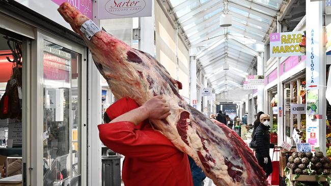 A delivery man transports meat to the butcher's shop at a market in Rome on March 12, 2020, as Italy shut all stores except for pharmacies and food shops in a desperate bid to halt the spread of a coronavirus. Picture: Alberto PIZZOLI / AFP.