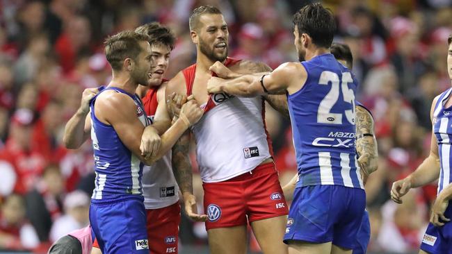 Lance Franklin wrestles with a couple of Kangaroos.