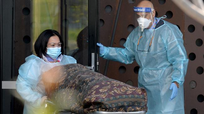 A body is removed from the Epping Gardens aged-care home in Melbourne, where 34 residents have been evacuated to hospital. Picture: Andrew Henshaw