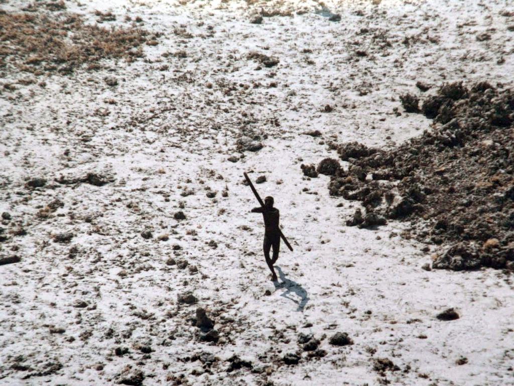 A man with the Sentinelese tribe aims his bow and arrow at an Indian Coast Guard helicopter as it flies over. Picture: AFP