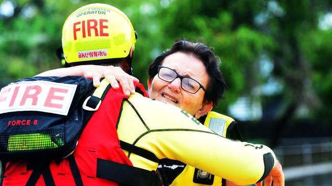 Tina Stephensen cries as she hugs a member of the Swift Water Rescue Crew that rescued her in Hermit Park. Picture: Zak Simmonds