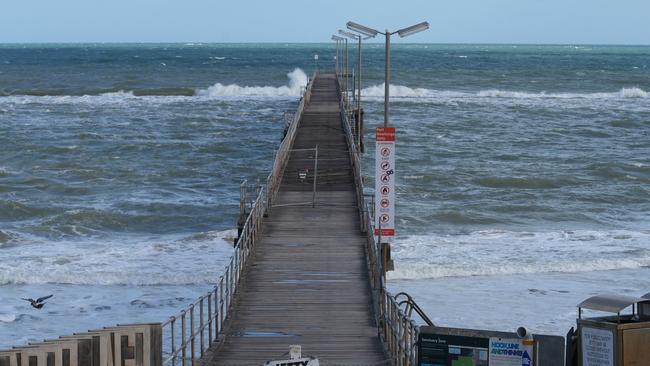 Port Noarlunga Jetty closed after it was severely damaged in yesterday’s storm. Locals, Stephen Ellis, Tracey Finch and John Belchamber, check out the damage. 27 May 2025. Picture: Dean Martin