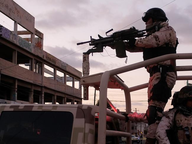 Mexican Soldiers leave the scene of a crime where a man was killed by gun fire in downtown Tijuana, Baja California state, Mexico, on April 21, 2019. - Violence in Mexico, besieged by bloodthirsty drug cartels that also engage in fuel theft, extortion and kidnapping, reached a new record during the first quarter of 2019 with 8,493 murders, according to official figures released on the weekend of April 20-21. (Photo by Guillermo Arias / AFP)