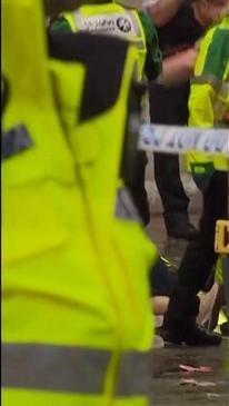 Emergency workers rush through with stretcher after car crashed through Liverpool crowd