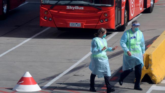 Transport crews and staff in PPE prepare for the first international passenger arrivals at Melbourne Airport. Picture: Andrew Henshaw