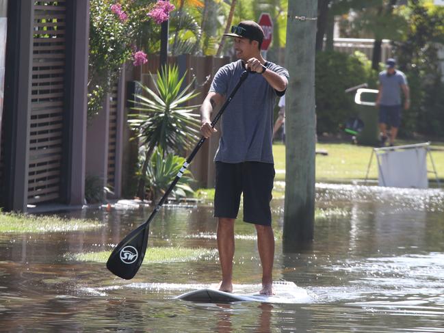 People out and about in the floodwater at Budds beach as it is  is inundated by the high tide. Picture Glenn Hampson