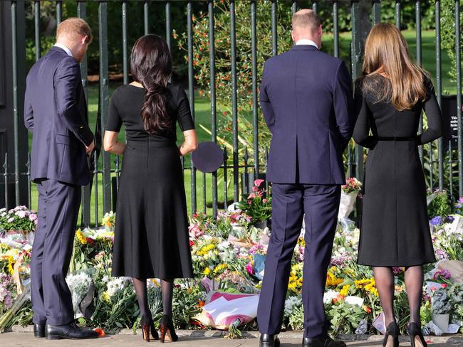 The great divide: The couples read notes of condolence left by wellwishers mourning the Queen’s death. Picture: AFP