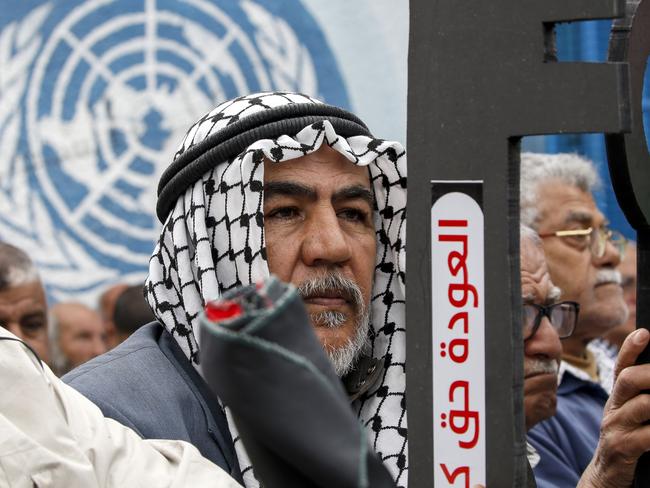 Palestinian refugees hold a key symbolising the "right of return" and a phrase in Arabic "return right like the sun"  during a protest against a US-brokered peace proposal, next the UN building in Gaza City on February 20, 2020. - US President Donald Trump's January 28 plan paves the way for Israeli annexation of much of the West Bank but also allows for a demilitarized Palestinian state. (Photo by MOHAMMED ABED / AFP)