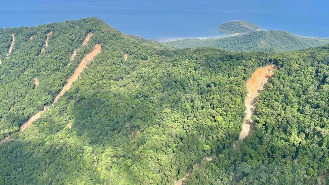 Scarred mountainsides highlight the damage done by Tropical Cyclone Jasper and the flood.