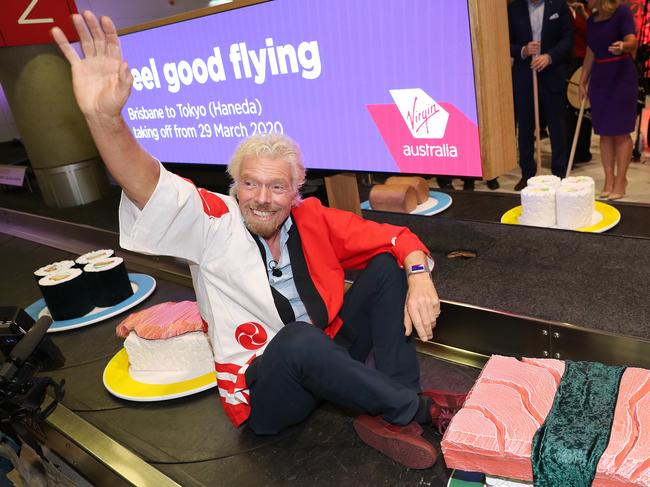 Eel good flying, Sir Richard Branson takes a ride on a makeshift sushi train, Virgin Australia promotes their new route from Brisbane to Japan, Brisbane Airport. Photographer: Liam Kidston.