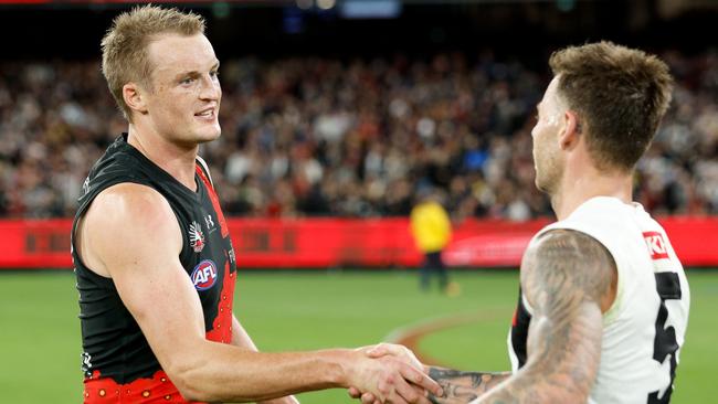 MELBOURNE, AUSTRALIA - APRIL 25: Jamie Elliott of the Magpies and Mason Redman of the Bombers shake hands after the game ends in a draw during the 2024 AFL Round 07 match between the Essendon Bombers and the Collingwood Magpies at the Melbourne Cricket Ground on April 25, 2024 in Melbourne, Australia. (Photo by Dylan Burns/AFL Photos via Getty Images)