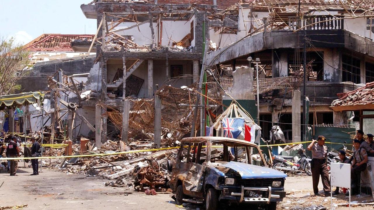 Forensic police officers and wreckage of a car at scene of the Sari Club nightclub blast in Kuta. Picture: AFP