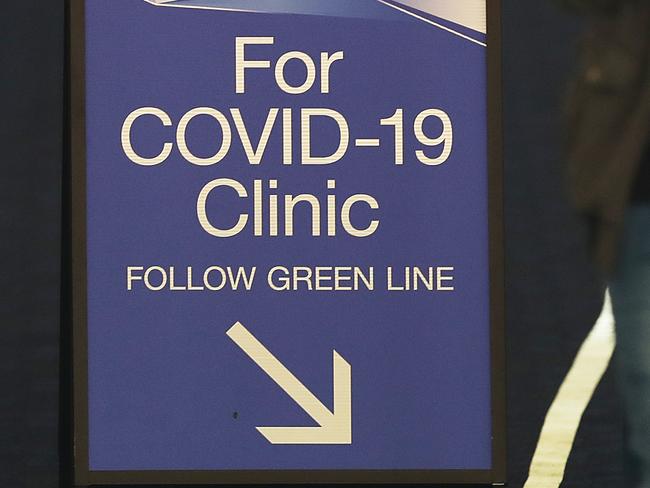 SYDNEY, AUSTRALIA - MARCH 18: People pass signs for a COVID -19 Clinic at St Vincent's hospital on March 18, 2020 in Sydney, Australia. The Prime Minister Scott Morrison today announced non-essential gatherings of 100 or more people indoors are banned and has declared a human biosecurity emergency. There are now 456 confirmed cases of COVID-19 In Australia - 210 in New South Wales, 94 in Victoria, 78 in Queensland, 32 in South Australia, 31 in Western Australia, seven in Tasmania, three in the Australian Capital Territory and one in the Northern Territory. There have been five confirmed deaths. (Photo by Mark Metcalfe/Getty Images)