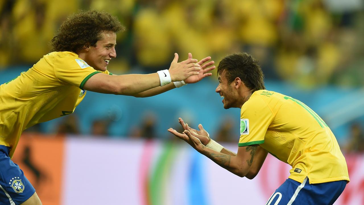 Brazil's forward Neymar (R) celebrates with his teammate defender David Luiz after scoring a penalty during a Group A football match between Brazil and Croatia at the Corinthians Arena in Sao Paulo during the 2014 FIFA World Cup on June 12, 2014. AFP PHOTO / VANDERLEI ALMEIDA