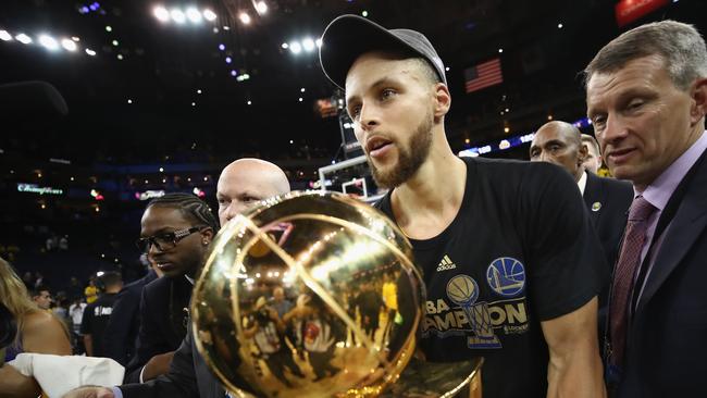 Stephen Curry cradles the Larry O’Brien trophy after his Warriors defeated Cleveland to take the 2017 NBA title. Picture: Getty Images