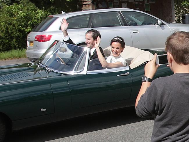 Pippa Middleton and James Matthews wave as they drive a Jaguar E-Type after their wedding. Picture: Yui Mok/PA Wire