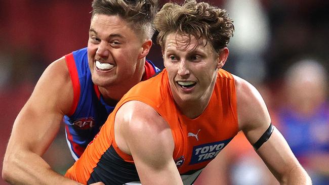 Lachie Whitfield tackled by Western Bulldogs Josh Schache during the Round 14 AFL match between the GWS Giants and Western Bulldogs.