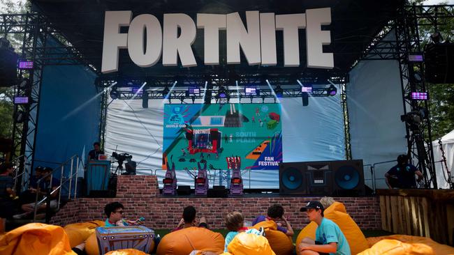 (FILES) In this file photo boys sit on pillows outside during the 2019 Fortnite World Cup Finals - Round Two on July 27, 2019, at Arthur Ashe Stadium, in New York City. - The maker of video game sensation 
