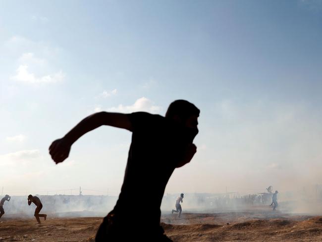 Palestinians run to take cover as an Israeli drone fires tear gas grenades in East Gaza City on Monday. Picture: AFP/Thomas Coex